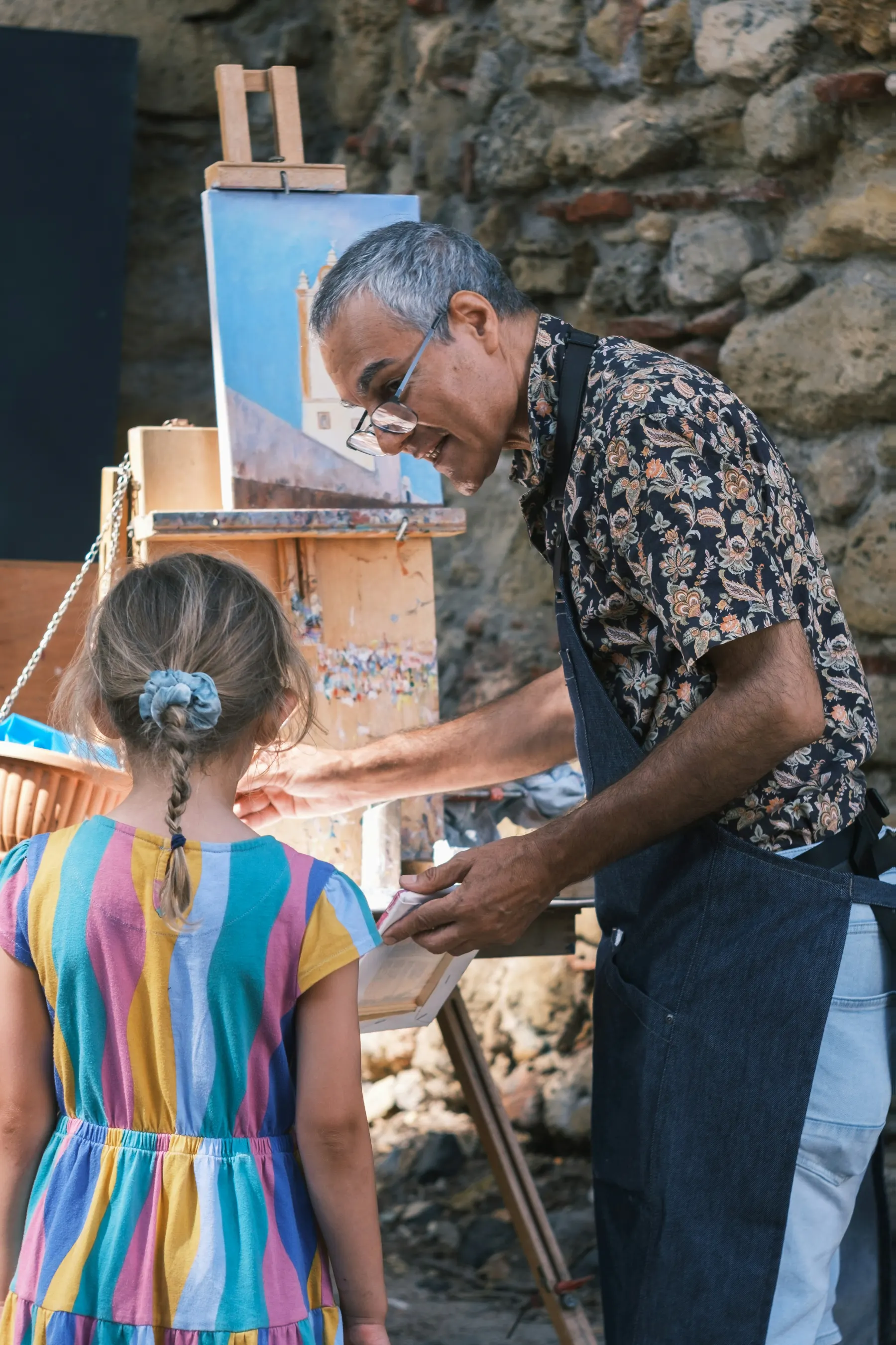 An adult guiding a child through a hands-on creative activity.