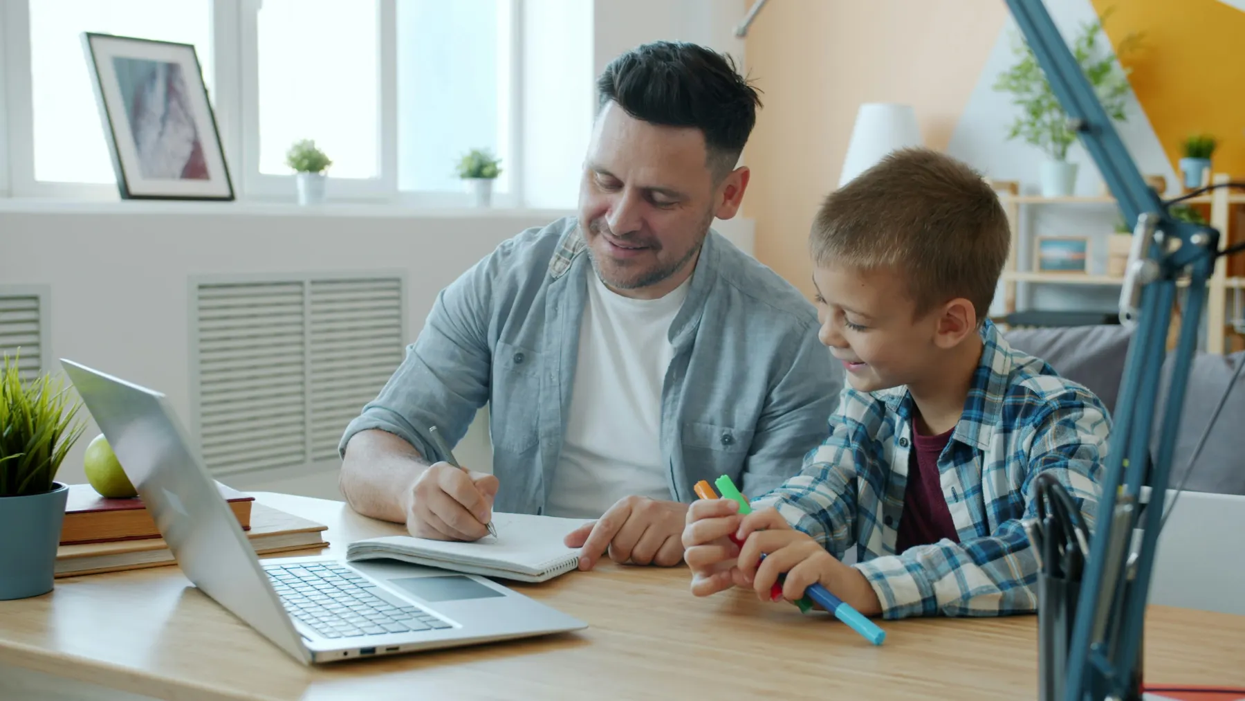 A mentor and child working together at a table.